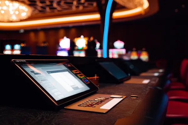 A man celebrating a winning moment on his laptop while gaming symbols float around him, capturing the excitement of 7555BET games.