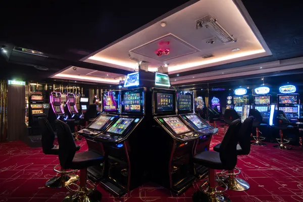 A woman in a luxurious green gown next to an ornate roulette wheel, capturing the upscale casino mood of 7555BET.